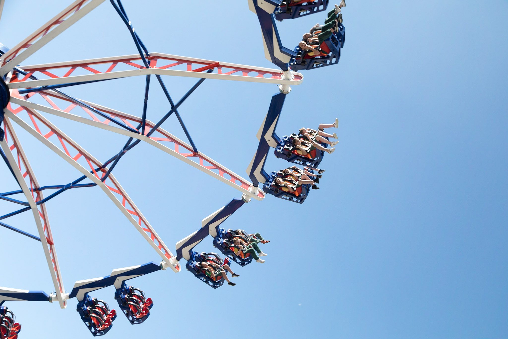 children on a theme park ride with a blue sky