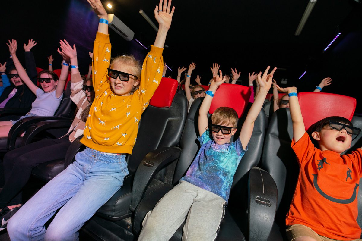 youngsters raising their hands during the 5D movie