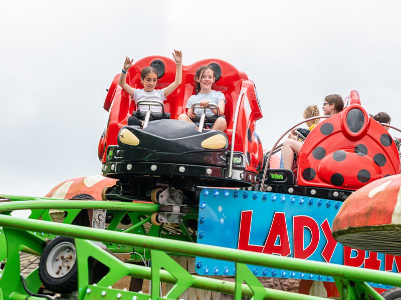 close up of girls on ladybird loop theme park attraction