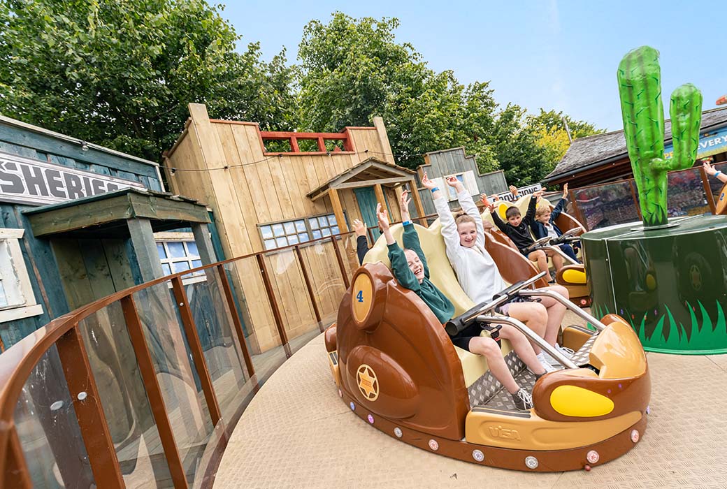 children waving hands at sheriffs shuffle ride in emerald park