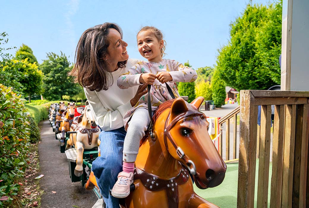 A mother and kid enjoying themselves at Emerald Park's pony rail.