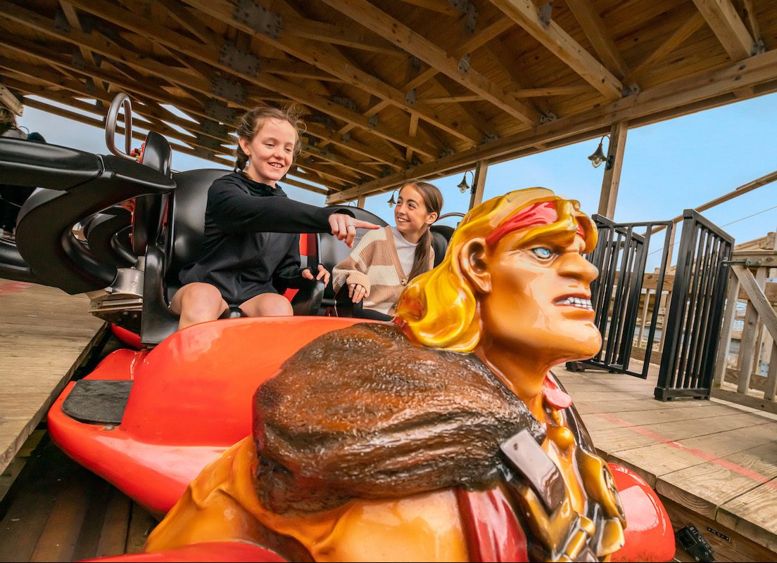 girl pointing at roller coaster car figure in emerald park