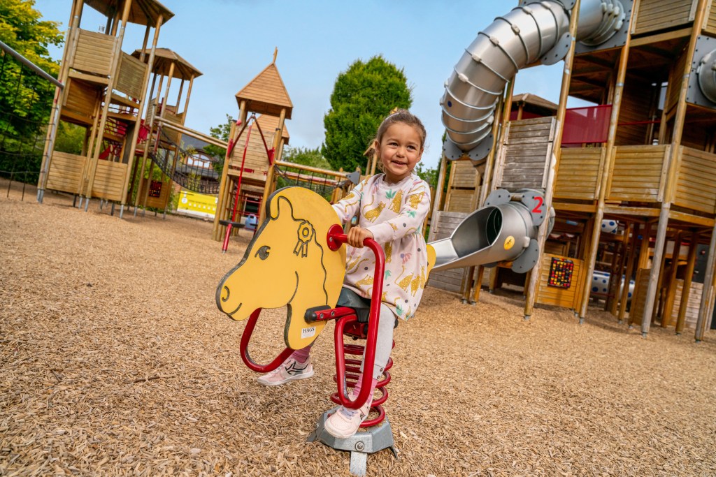 a child playing on a spring horse at a playground