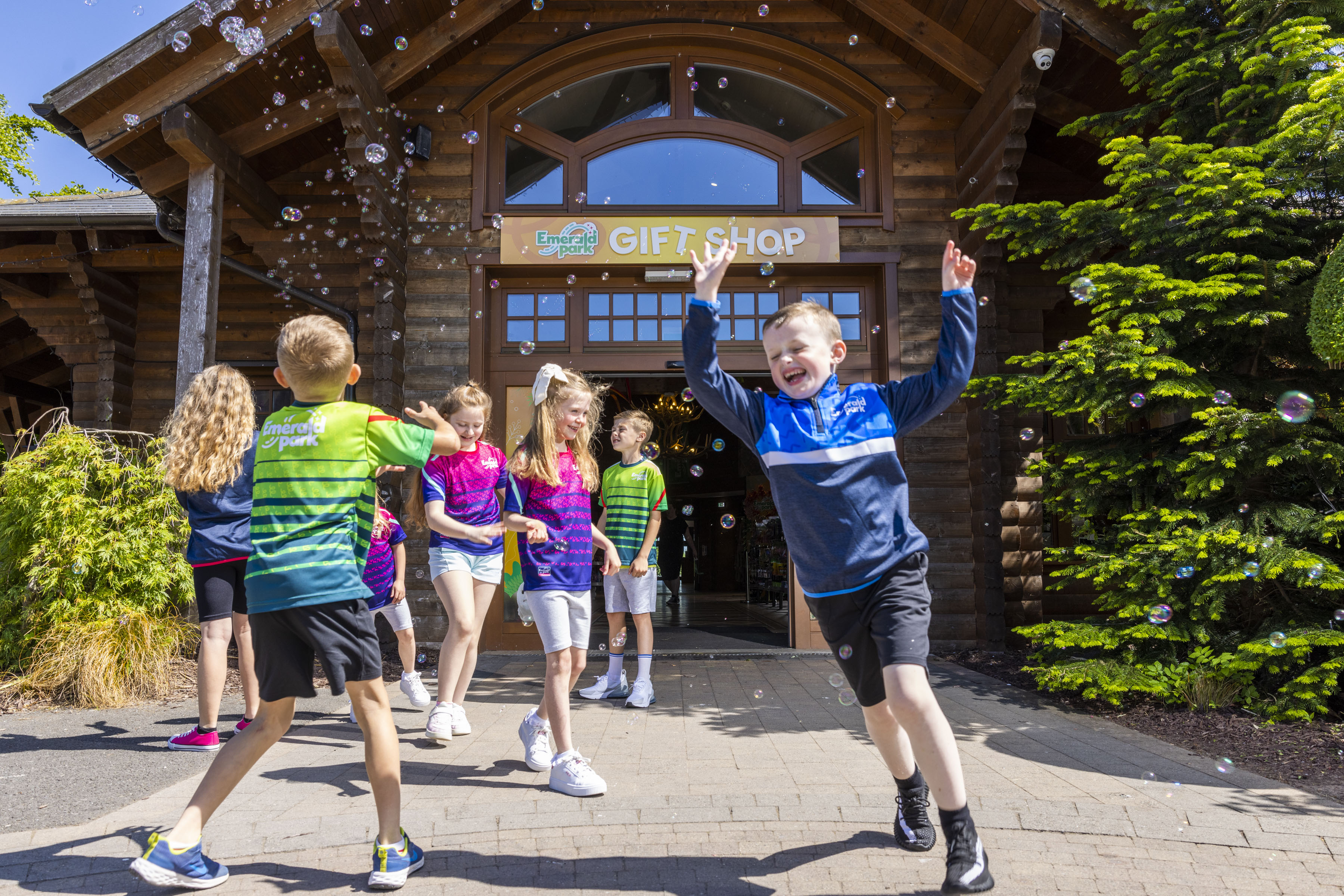 a group of children outside the gift shop at Emerald Park playing with bubbles