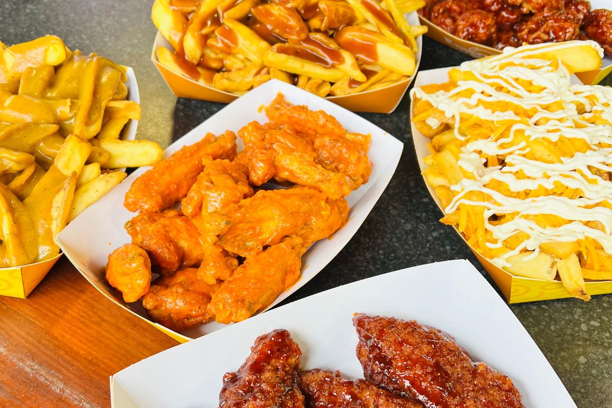 a spread of food items including chicken and topped fries