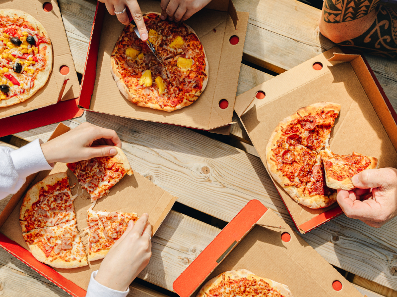 A close up of people taking a slice of pizza