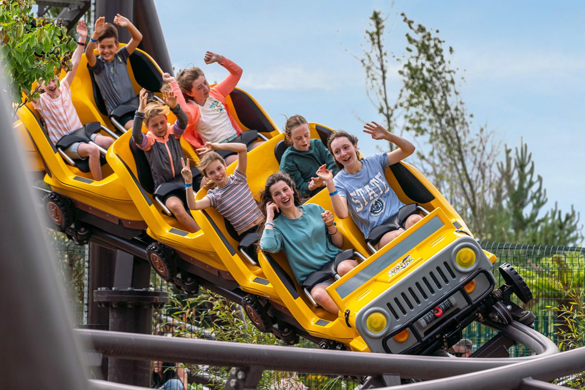 Children enjoying themselves on the dino dash ride at the theme park