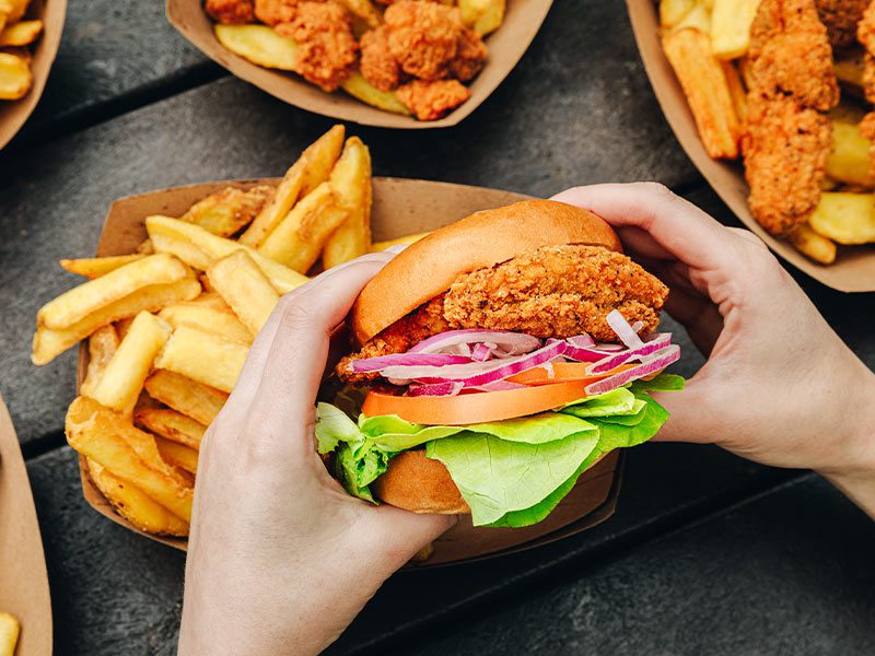 a close up of a person holding of burger