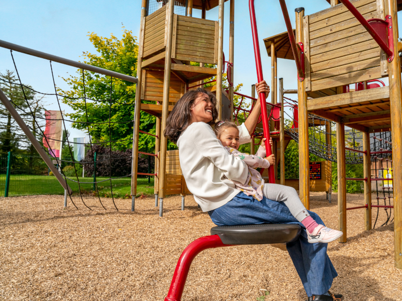 A mother and child having fun on playground ride