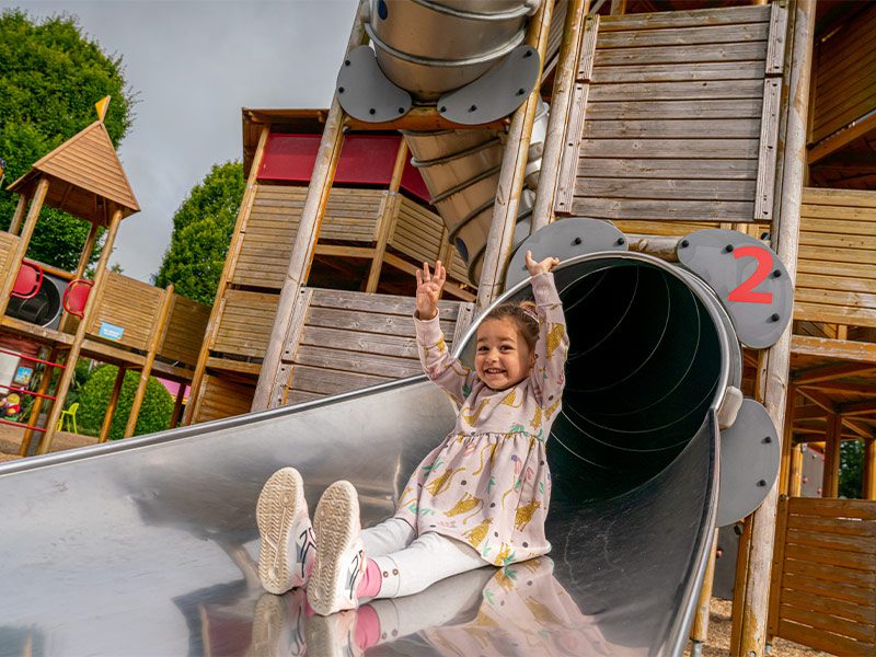 A child sliding down a slide at Emerald park playground