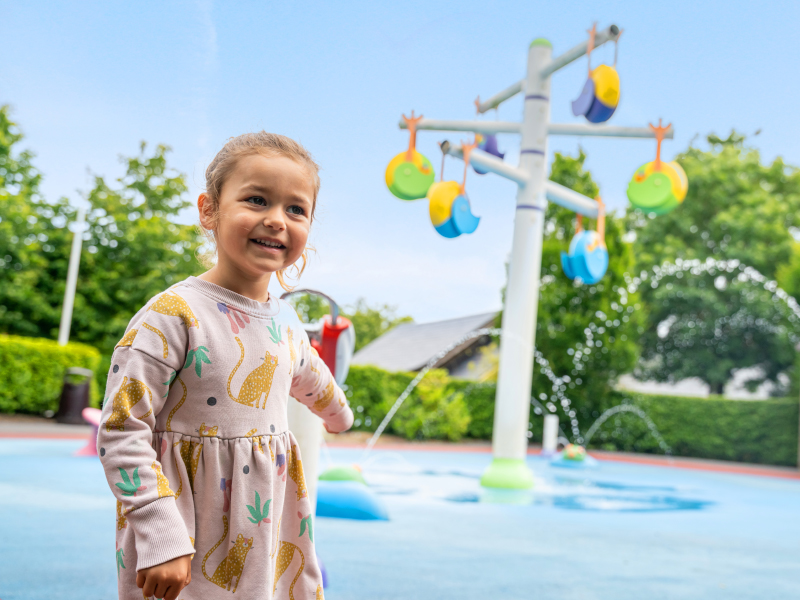 A little girl having fun at the water load area at emerald park.