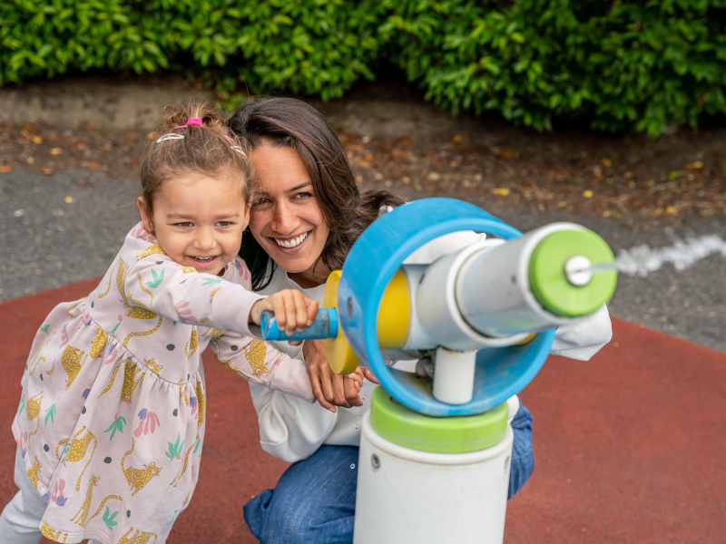 child and woman playing with water feature