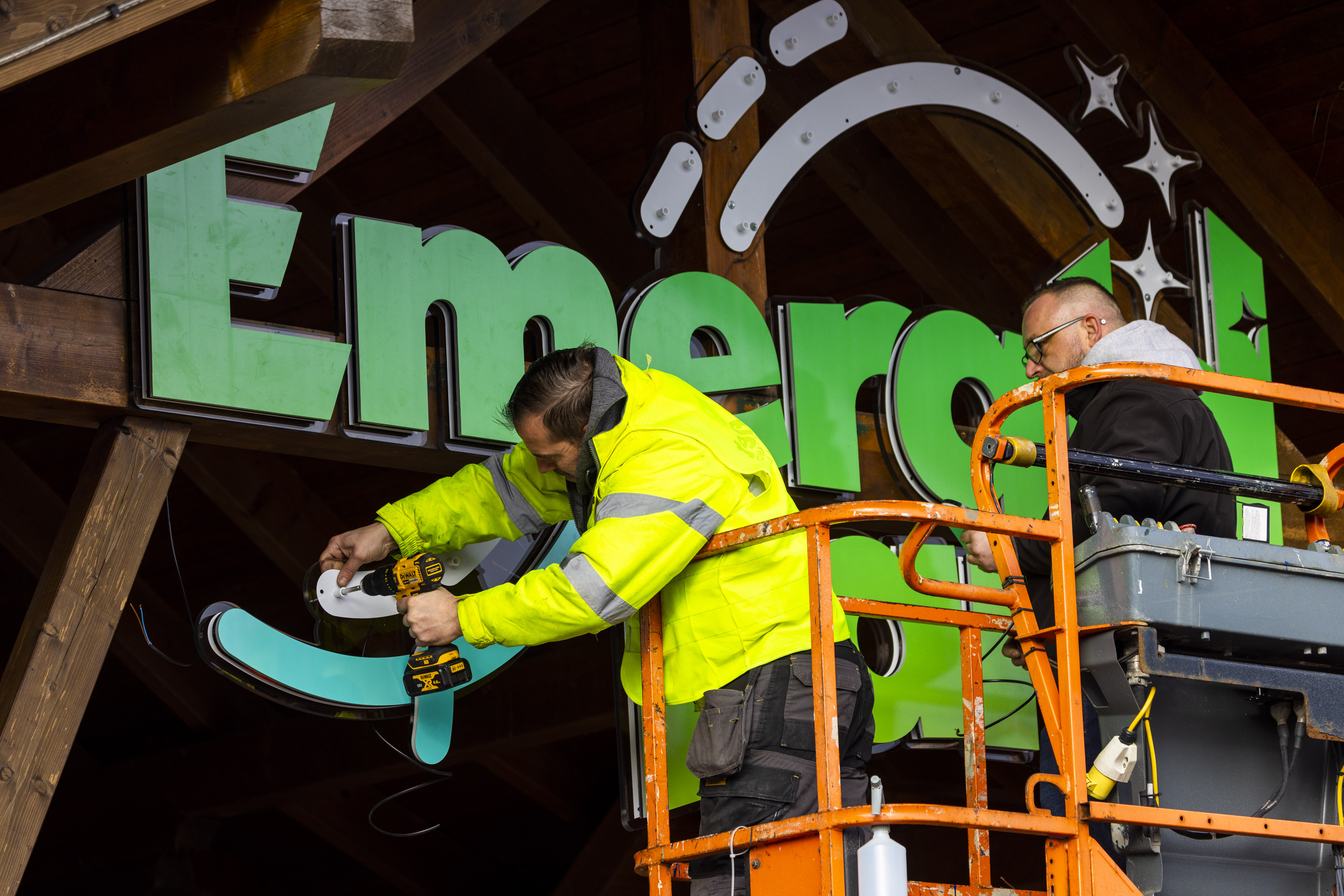 two men installing a large sign