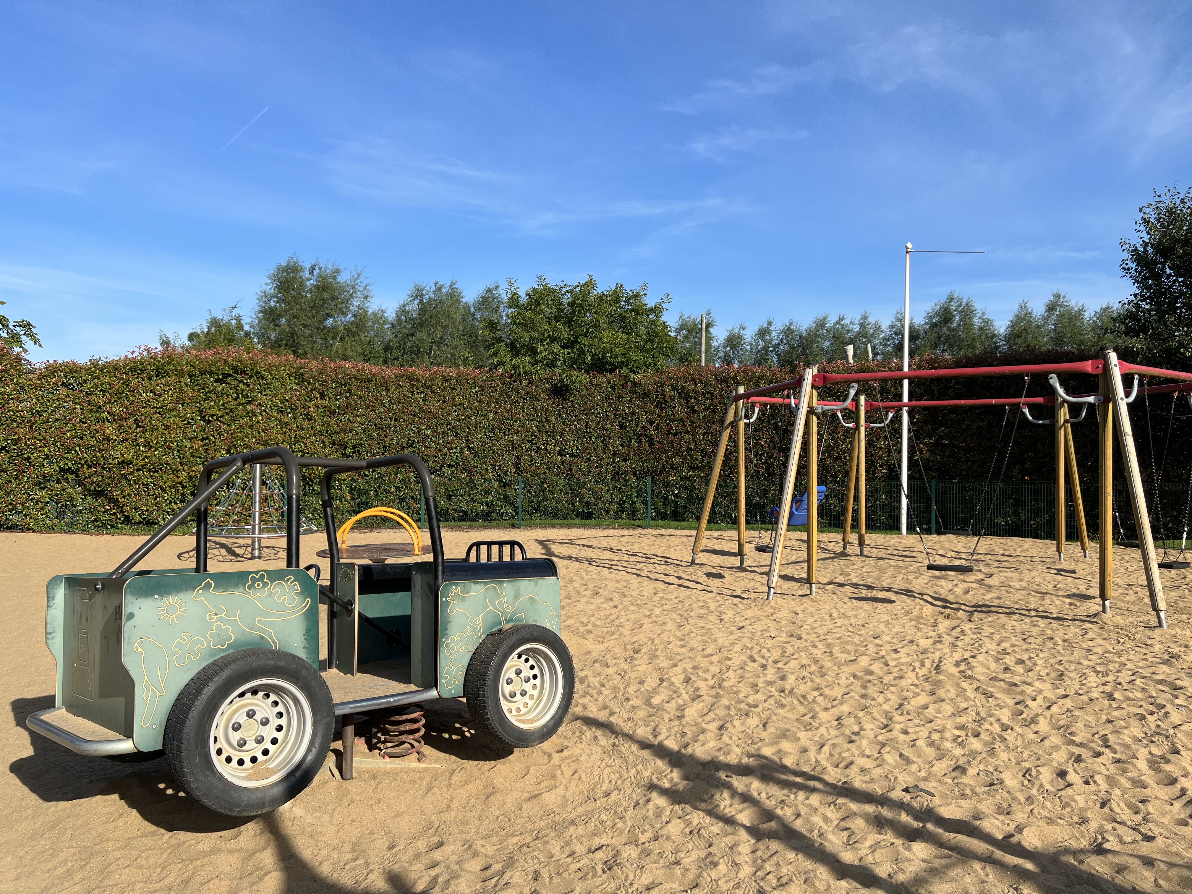 a playground with swings and a spring based ride