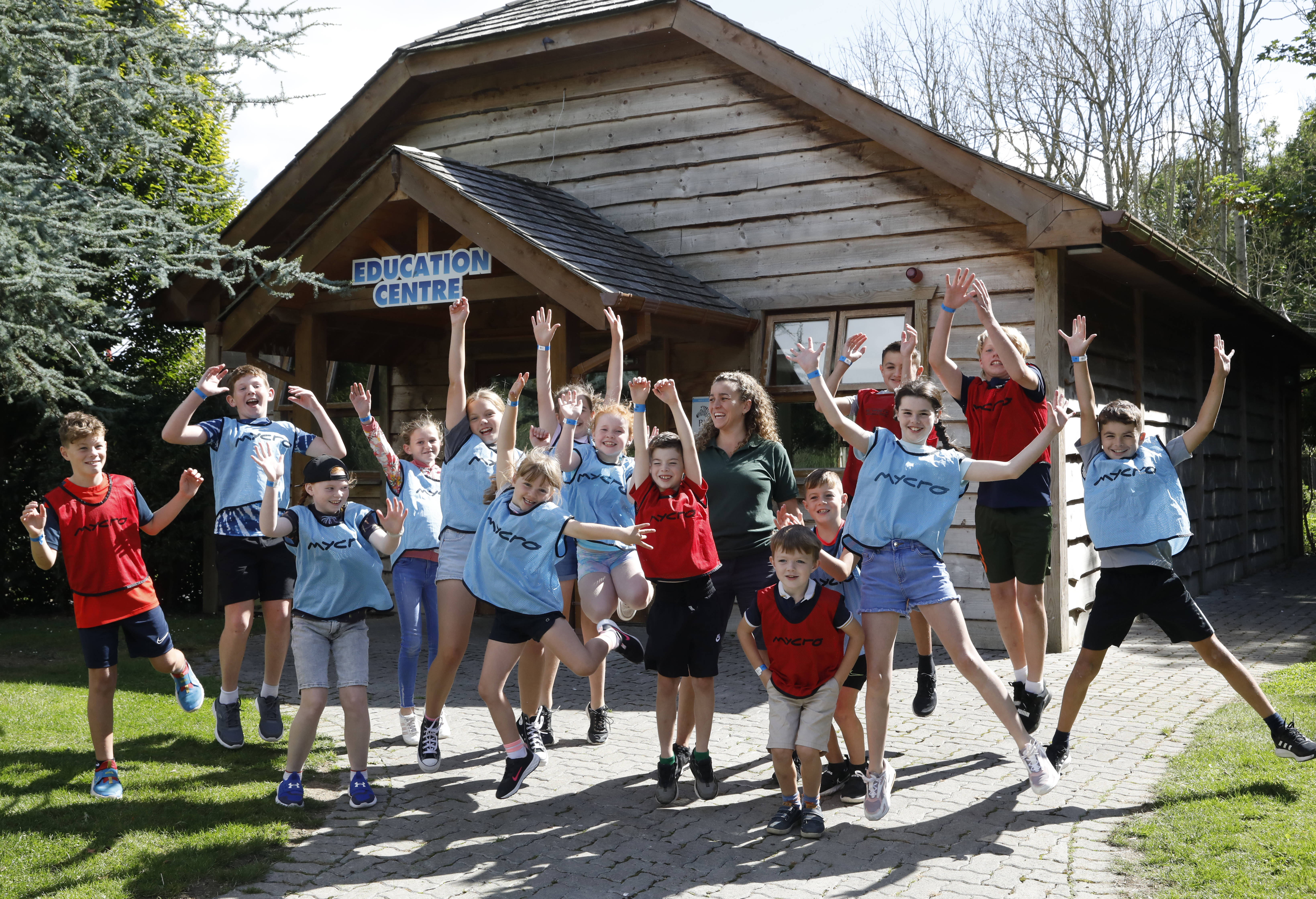 a group of children on a school tour jumping in the air