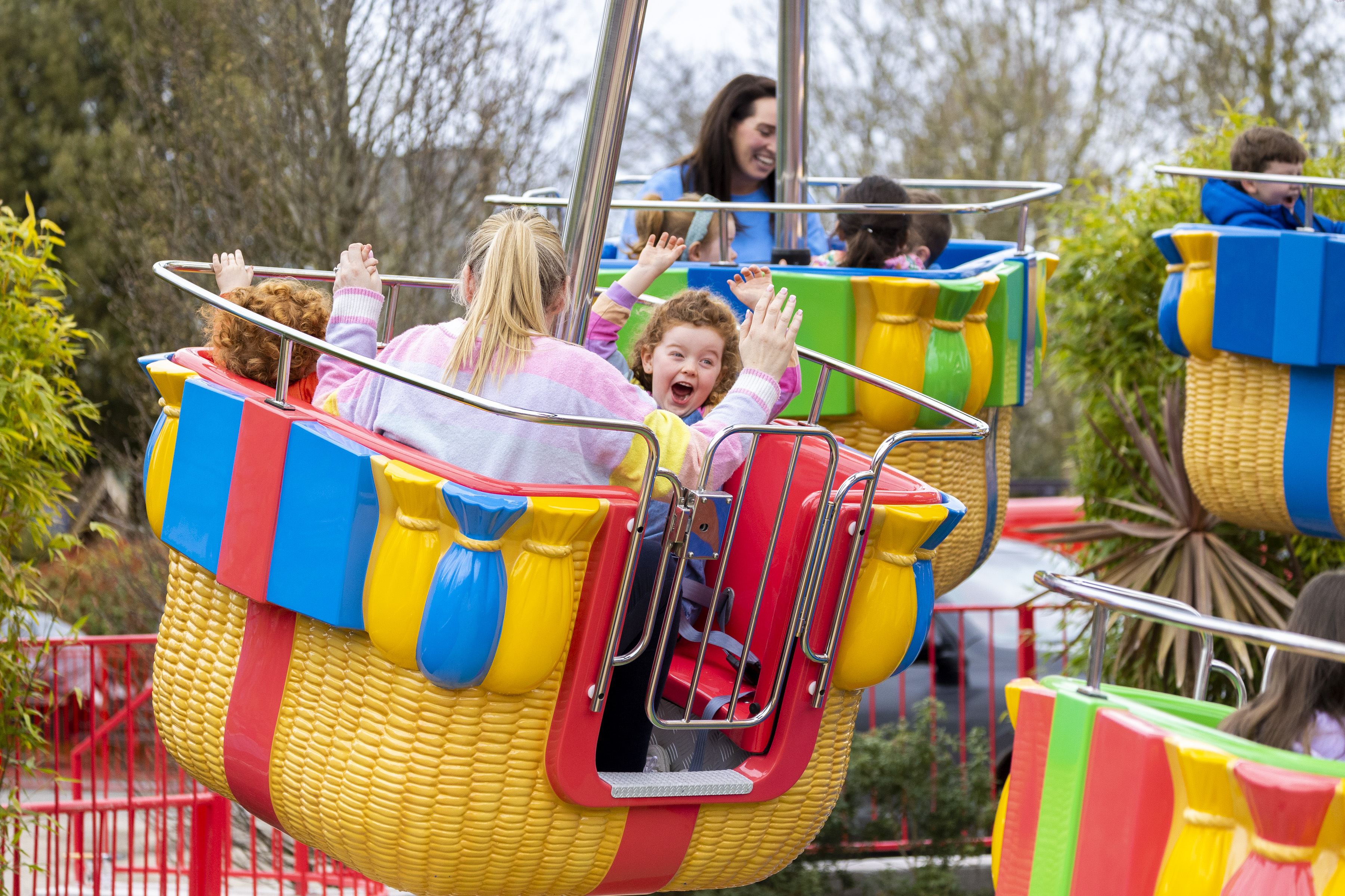 a hot air balloon inspired theme park attraction with a child smiling