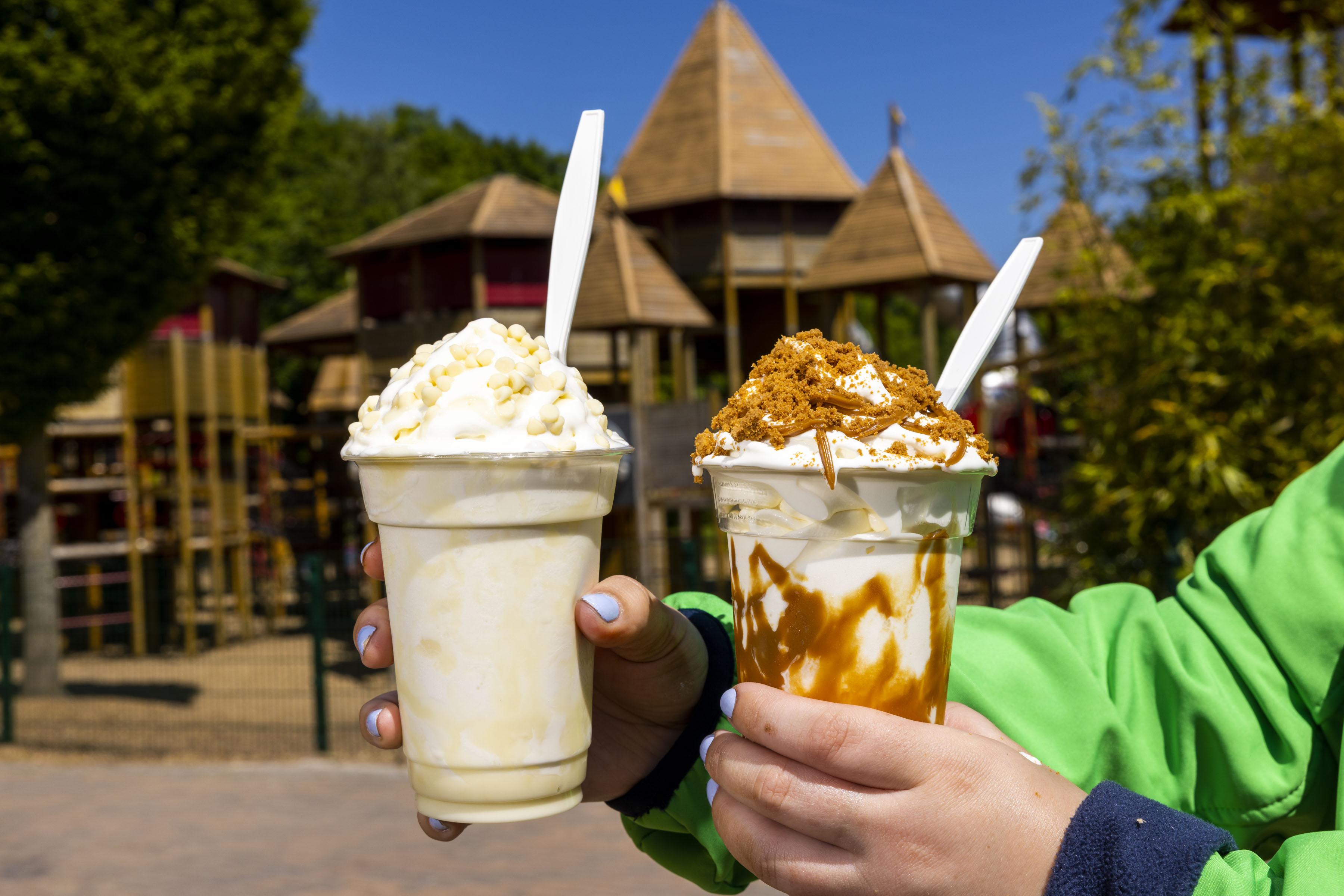 two tubs of ice cream with a playground in the back