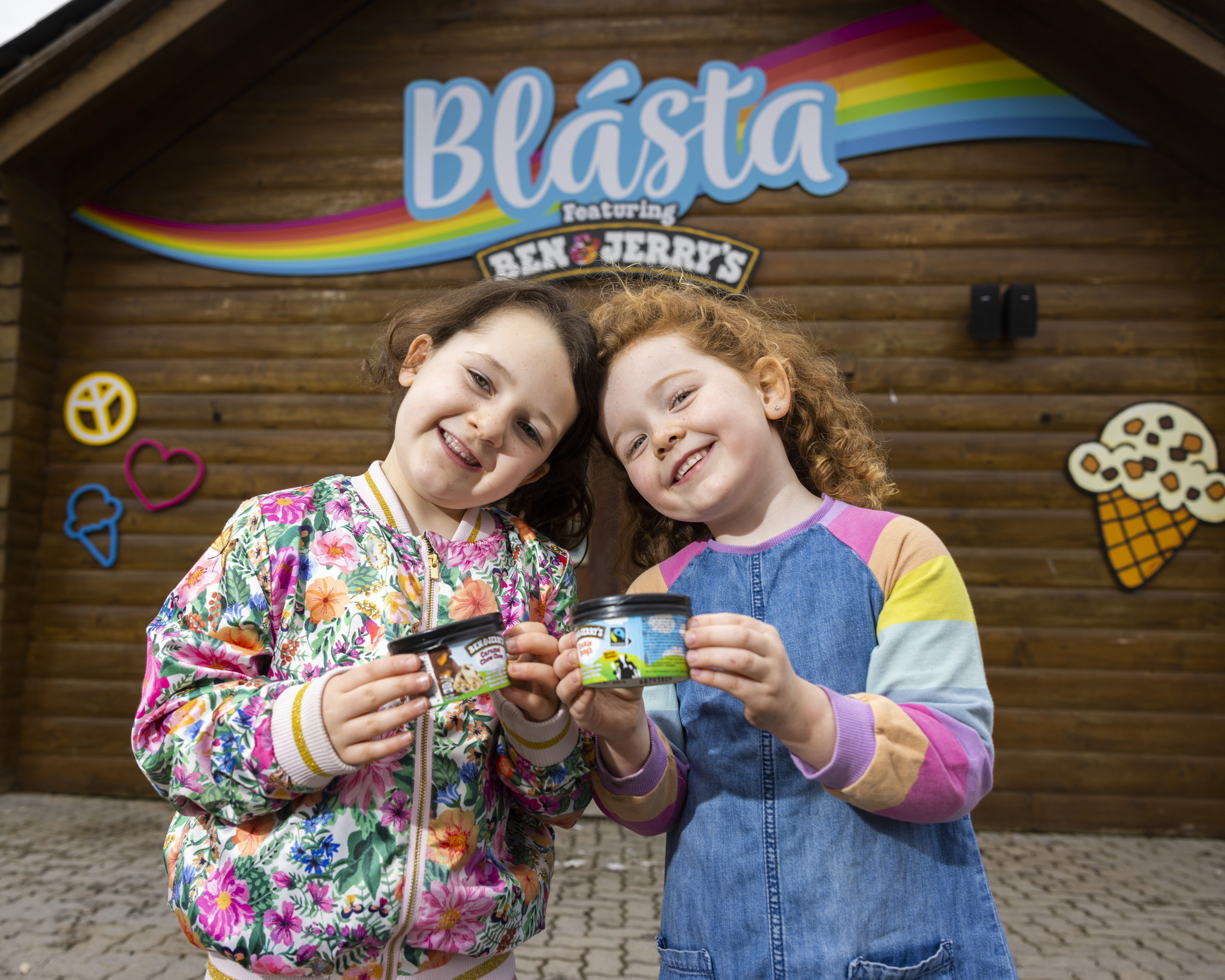 two children outside an ice cream parlour holding tubs of Ben & Jerry's ice cream