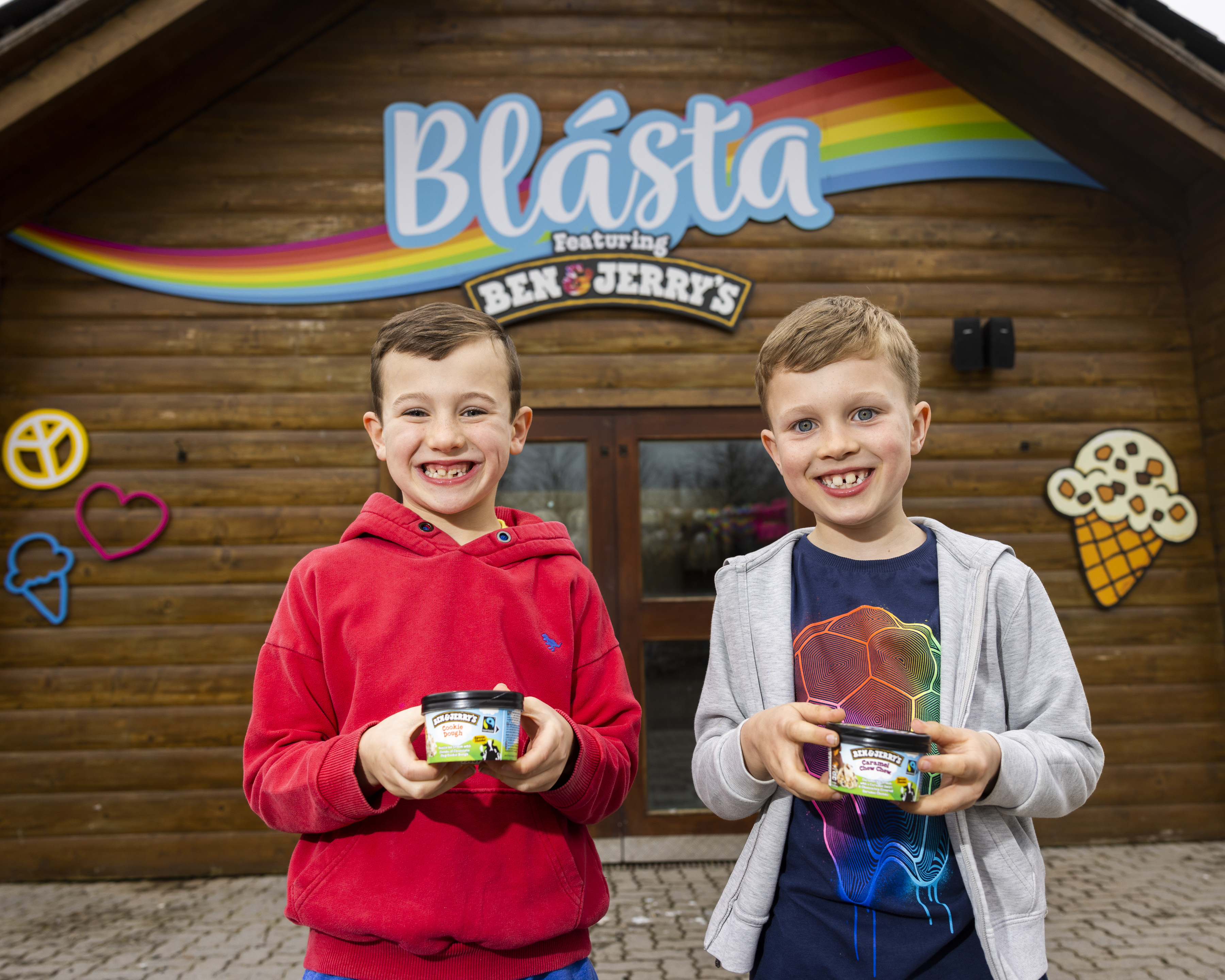two boys posing outside an ice cream shop with Ben & Jerry's ice cream