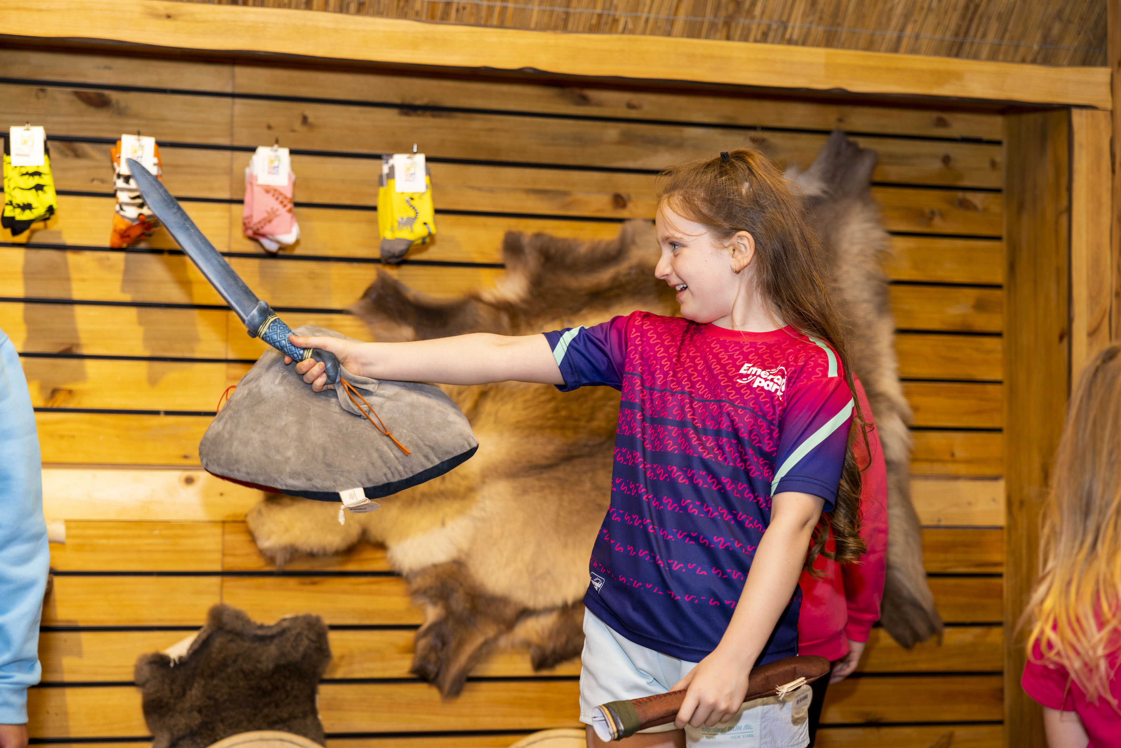 a girl with a toy sword in a shop