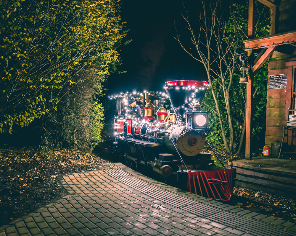 a steam train attraction lit up at night time