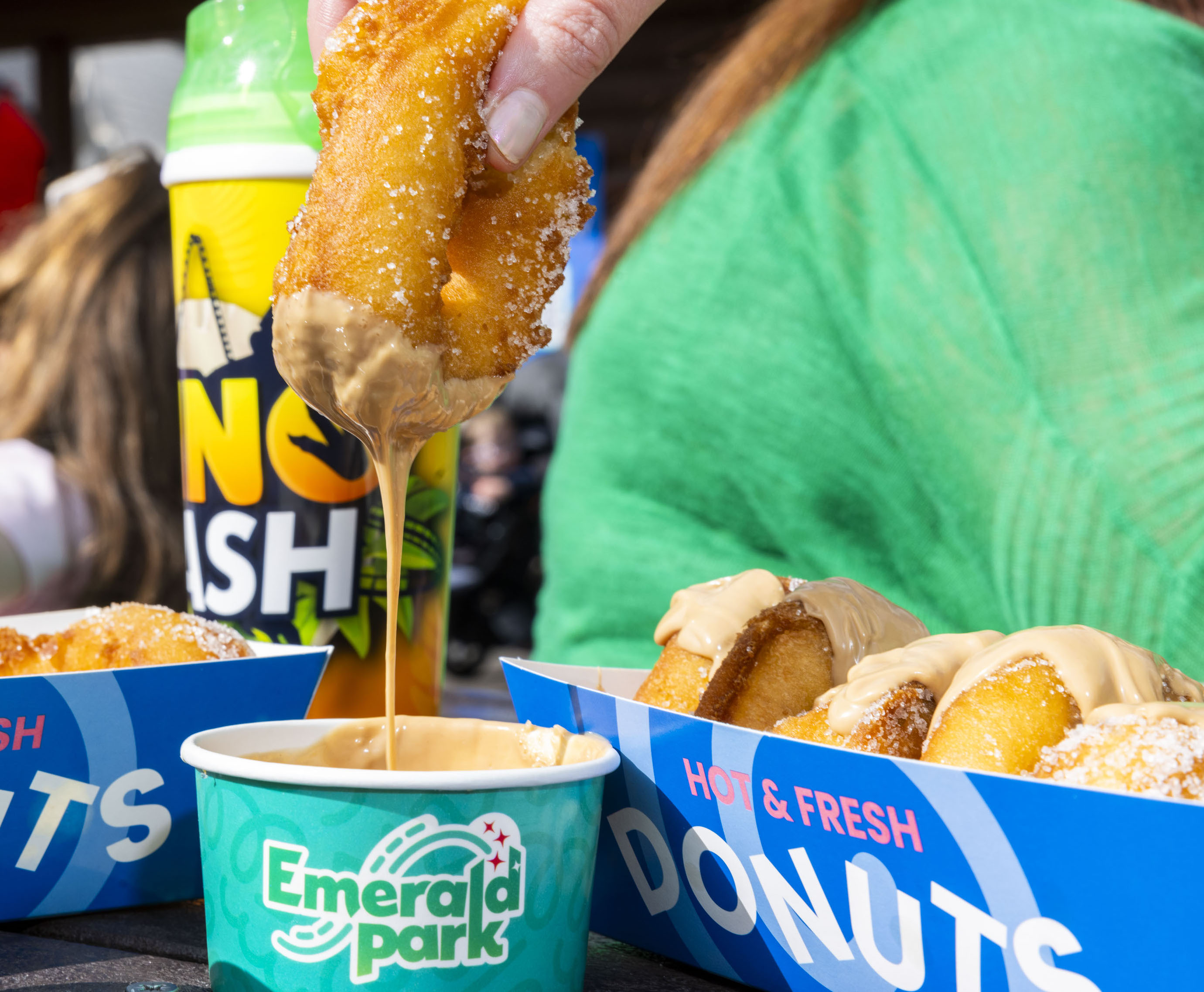 a portion of sugar doughnuts. One doughnut is dipped into a tub of kinder bueno sauce