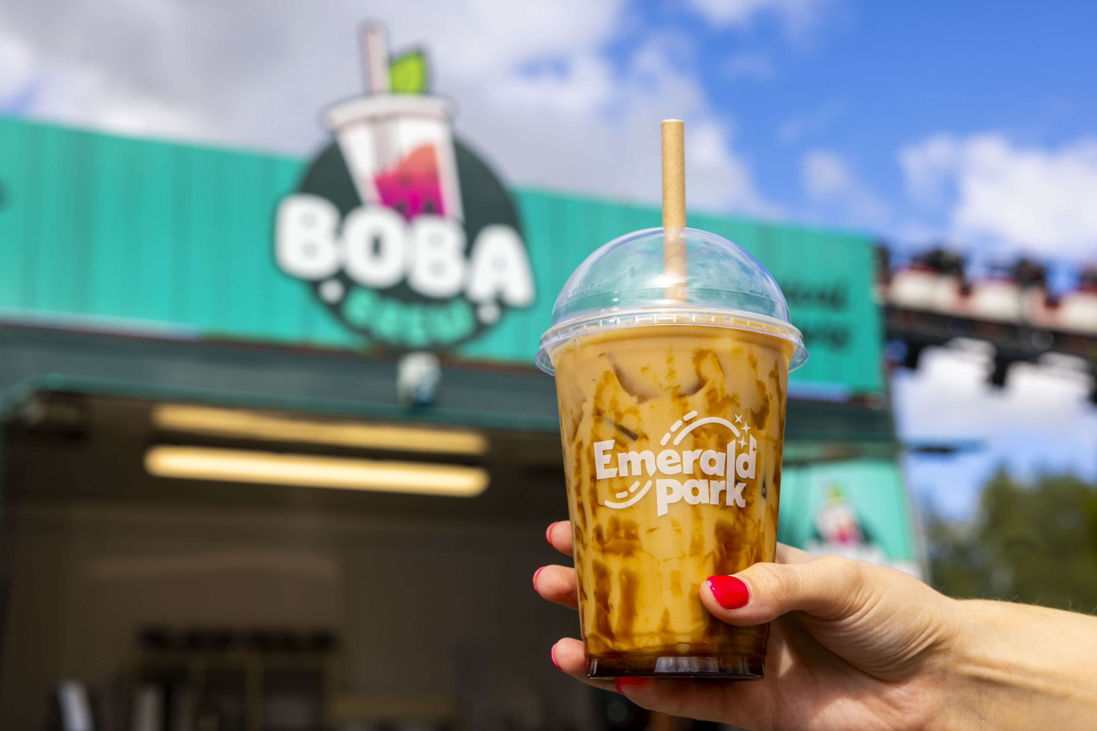 an iced coffee in an Emerald Park cup in front of a unit called Boba Brew