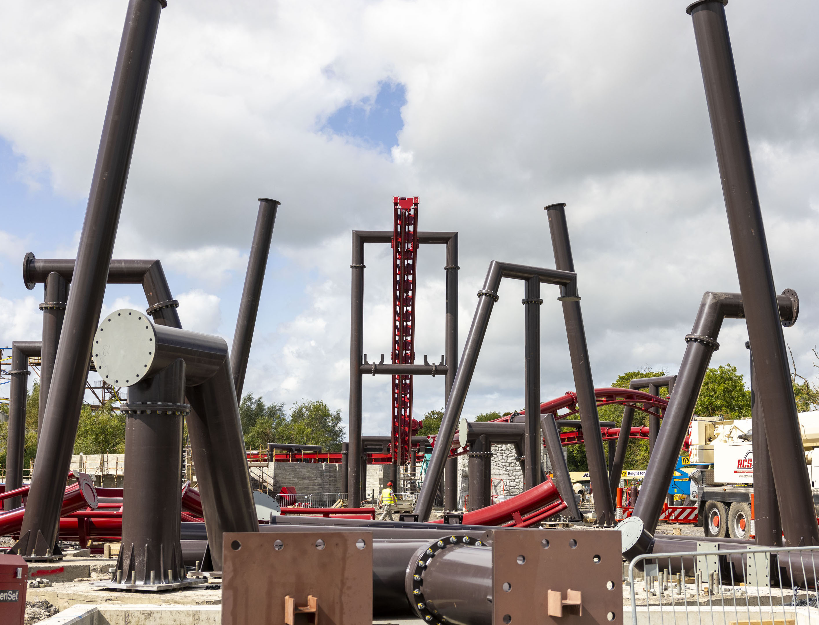 a red rollercoaster track being built. A section of the track lift hill can be seen.